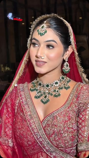 Bride in red lehenga with emerald jewellery
